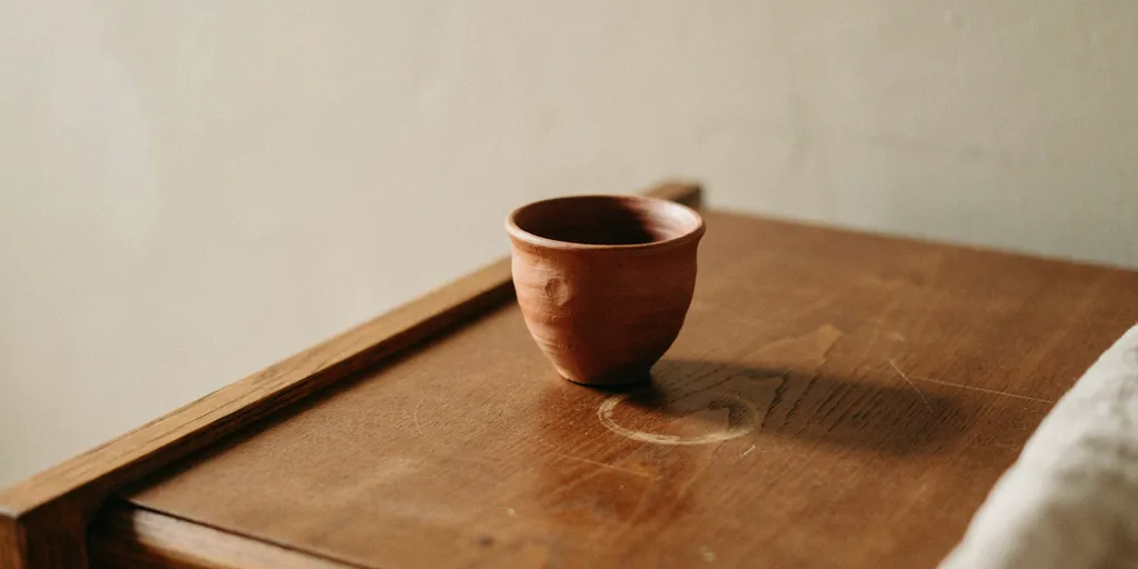 Close view of an oiled oak surface with the grain clearly visible under a waxed matte finish, small marks sitting into the wood rather than on it
